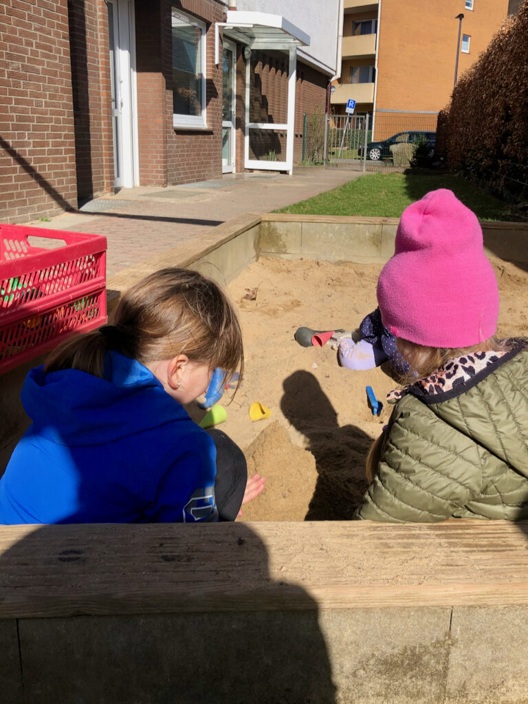 Zwei Mädchen spielen gemeinsam in der Sandkiste