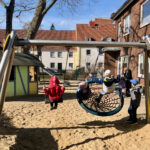 Kinder beim Schaukeln mit normaler Schaukel und Korbschaukel