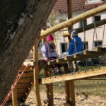 Zwei Kinder sind gemeinsam auf dem Klettergerüst