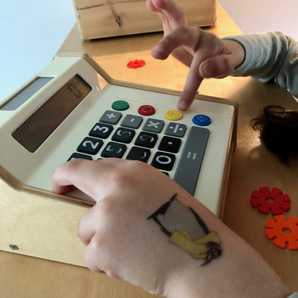 Kinderhände spielen mit Spielzeugkasse